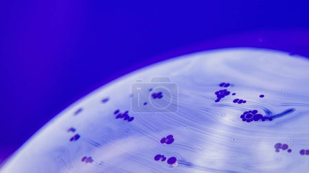Téléchargez les photos : Gros plan d'un objet rond avec des bulles sur fond violet - en image libre de droit