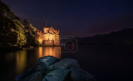 A dark shot of the Chillon Castle on Lake Geneva in Vaud, Switzerland during nighttime