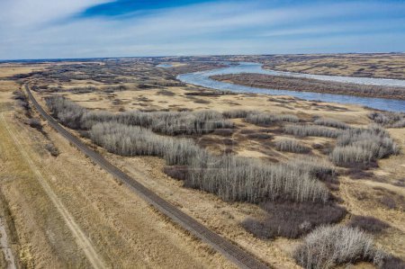 Téléchargez les photos : Vue aérienne d'un vaste champ et de la rivière Saskatchewan Sud sous le ciel bleu - en image libre de droit