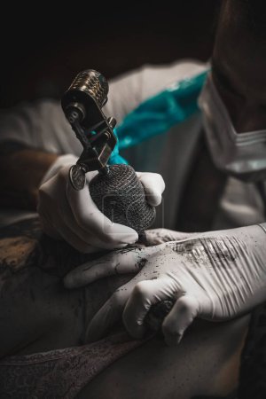 Foto de Una foto vertical de un tatuador llenando un tatuaje - Imagen libre de derechos
