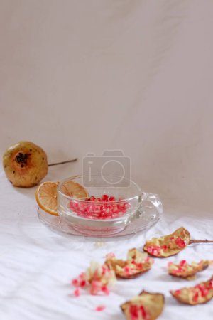 Foto de Tiro vertical de semillas de granada en una taza de vidrio para hacer jugo de fruta fresca para una refrescante bebida de verano - Imagen libre de derechos