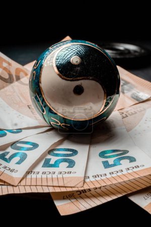 Foto de Una toma vertical de un símbolo chino yin-yang en billetes de 50 euros. - Imagen libre de derechos