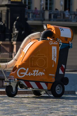 Photo for Cleaning worker cleaning the sidewalks of the city park with a Glutton which is an electric vacuum cleaner for urban and industrial waste - Royalty Free Image