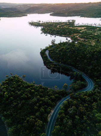 Téléchargez les photos : Vue aérienne d'une route tourbillonnante entre les collines d'Adélaïde surplombant un réservoir pendant la journée en Australie - en image libre de droit
