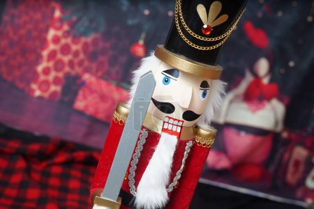 Téléchargez les photos : Décoration de Noël en bois casse-noisette avec épée chapeau barbe et présente vacances festives - en image libre de droit