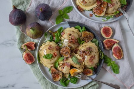 Photo for A plate of tasty pumpkin tortellini with fresh figs and herbs - Royalty Free Image