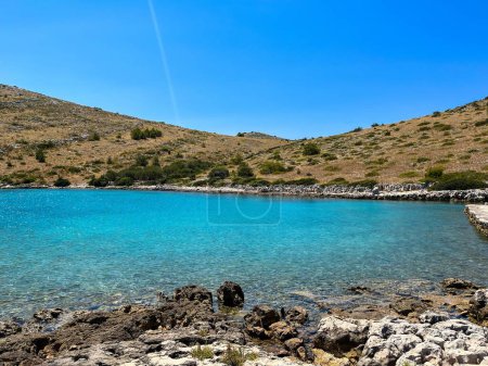 Photo for A beautiful view of a lake with a rocky shore under the blue sky - Royalty Free Image