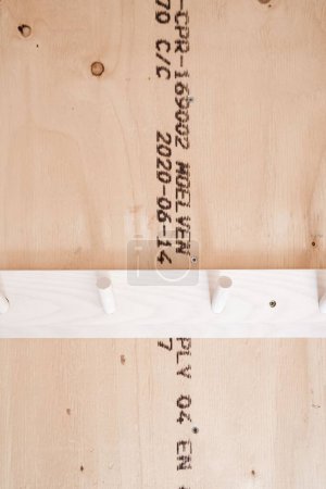 Photo for A vertical shot of white Hangars on bright wooden wall with text on it - Royalty Free Image
