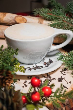 Photo for A closeup of a cappuccino with spruce branches on a table - Royalty Free Image