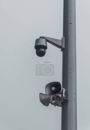 Foto de Un primer plano de una cámara de seguridad y altavoces en un poste en un día de niebla - Imagen libre de derechos