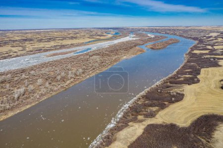 Foto de Una toma aérea de un amplio campo y el río Saskatchewan Sur bajo el cielo azul - Imagen libre de derechos