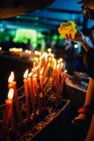 Téléchargez les photos : Une mise au point peu profonde de l'éclairage des bougies votives avec des visiteurs en arrière-plan à l'intérieur d'une église - en image libre de droit