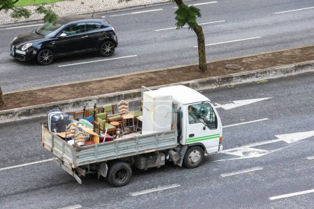 Téléchargez les photos : Une camionnette à boîte ouverte avec divers meubles usagés - en image libre de droit