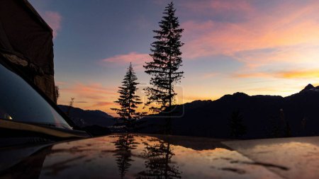 Téléchargez les photos : Plan rapproché d'une voiture reflétant le ciel rose nuageux au coucher du soleil à Squamish, Colombie-Britannique, Canada - en image libre de droit