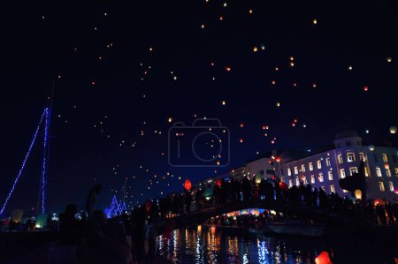 Téléchargez les photos : Une scène magique de lanternes scintillantes flottant dans la nuit à Volos, en Grèce, créant l'esprit de Noël - en image libre de droit