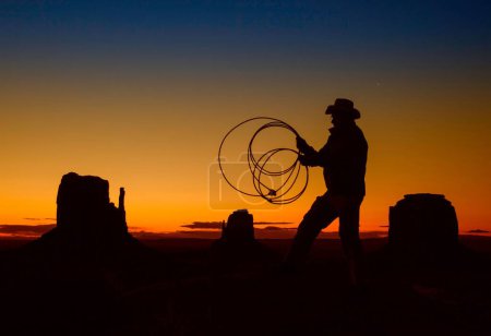 Photo for A silhouette shot of a cowboy holding a whip during sunrise - Royalty Free Image