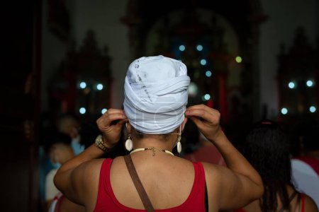 Téléchargez les photos : Salvador, Bahia, Brésil - 04 décembre 2022 : Des dévots observent la messe à l'église Rosario dos Pretos en l'honneur de Santa Barbara. Ville de Salvador, Bahia. - en image libre de droit