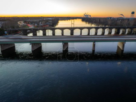 Photo for A drone shot of a bridge over river at sunrise and Trenton city in the background in New Jersey - Royalty Free Image