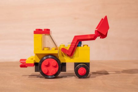 Photo for A closeup shot of a vintage Lego model of an excavator placed on a wooden surface - Royalty Free Image