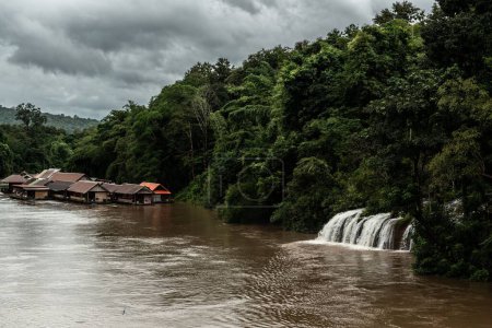 Téléchargez les photos : Une vue panoramique sur la paisible rivière Kwai entourée de radeaux traditionnels et d'une jungle à feuilles persistantes - en image libre de droit