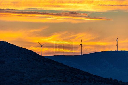 Photo for A mesmerizing view of windmills on top of evergreen mountains during a scenic sunset in Croatia - Royalty Free Image