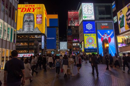 Foto de Un primer plano de personas caminando por la calle por la noche en Osaka, Japón - Imagen libre de derechos