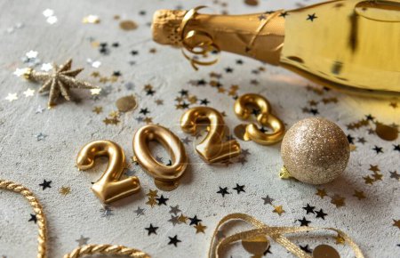 Foto de Foto de paleta de colores dorados con números de año nuevo 2023 rodeados de confeti y decoraciones - Imagen libre de derechos