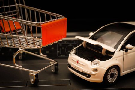 Foto de Un carrito de compras en miniatura y un coche - Imagen libre de derechos