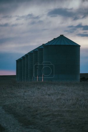 Téléchargez les photos : Un plan vertical de plusieurs silos en acier alignés lors d'un coucher de soleil pittoresque - en image libre de droit