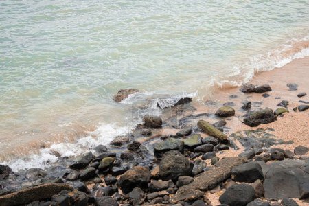 Téléchargez les photos : Une vue rapprochée d'un littoral rocheux avec une mer calme vagues - en image libre de droit