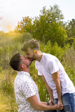 Téléchargez les photos : Un plan vertical d'un baiser couple gay hispanique en plein air. - en image libre de droit
