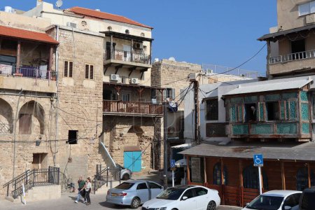 Téléchargez les photos : Une vieille maison typique dans la vieille ville d'Acre avec des voitures garées dans la cour, Israël - en image libre de droit