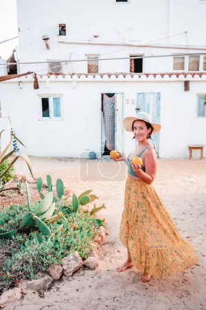 Téléchargez les photos : Une femelle dans un chapeau jongler oranges dans un été chaud - en image libre de droit
