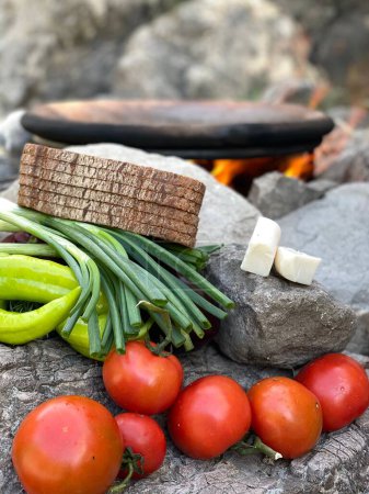 Foto de Un disparo vertical de trozos de pan, queso y verduras en las rocas en un jardín de la casa durante el día - Imagen libre de derechos
