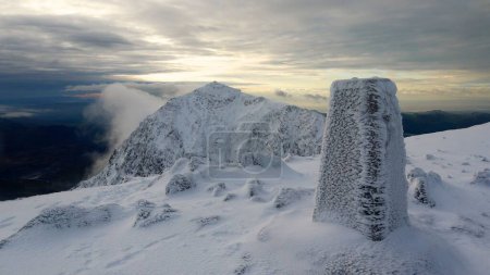 Foto de Una cumbre de la nevada montaña Snowdon con un fondo nublado, Gales, Reino Unido - Imagen libre de derechos
