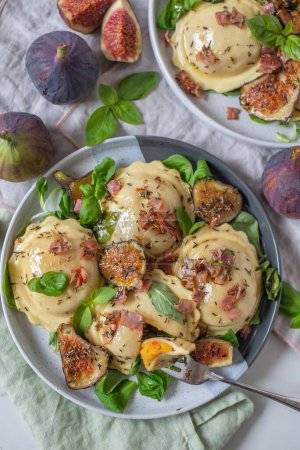 Photo for A plate of tasty pumpkin tortellini with fresh figs and herbs - Royalty Free Image