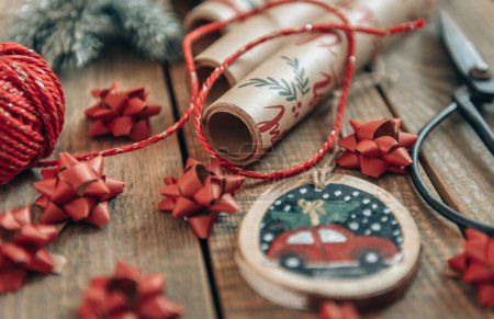 Téléchargez les photos : Photo en gros plan des décorations de Noël et du papier d'emballage sur des planches en bois - en image libre de droit