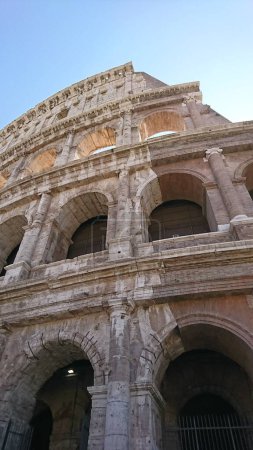 Foto de Un plano vertical del famoso antiguo Coliseo de Roma contra el cielo azul - Imagen libre de derechos