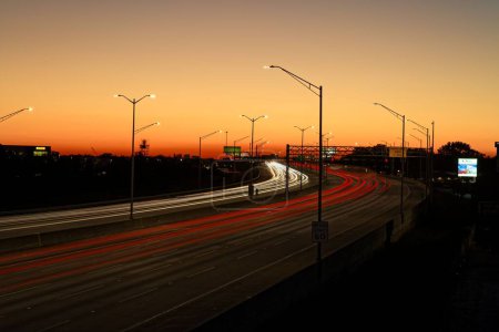 Téléchargez les photos : Une vue aérienne de la route avec des sentiers lumineux au coucher du soleil - en image libre de droit