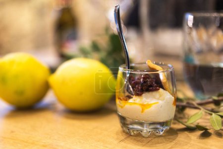 Téléchargez les photos : Un plan de mise au point peu profond d'une mousse crémeuse aux fruits secs avec des citrons en arrière-plan - en image libre de droit