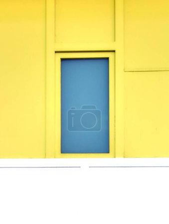 Téléchargez les photos : Un bâtiment jaune avec fenêtre bleue - en image libre de droit