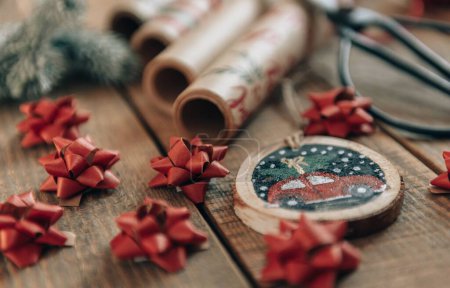 Téléchargez les photos : Photo en gros plan des décorations de Noël et du papier d'emballage sur des planches en bois - en image libre de droit