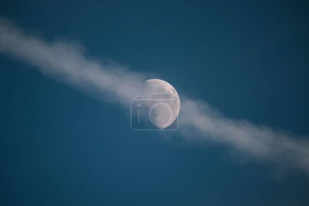 Foto de Una hermosa toma de nubes que se extienden contra media luna en el cielo azul - Imagen libre de derechos