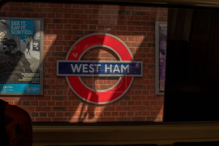Photo for A closeup of a London underground sign of West Ham on a brick wall - Royalty Free Image