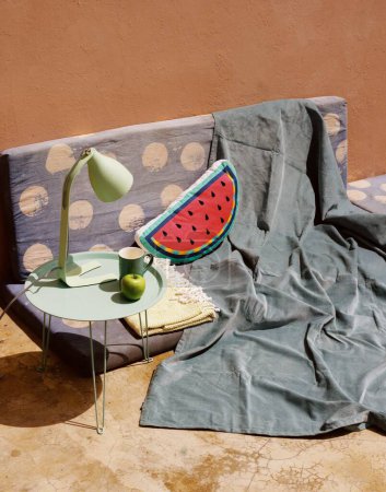 Photo for A cozy nook watermelon pillow placed on a mattress with a blanket - Royalty Free Image