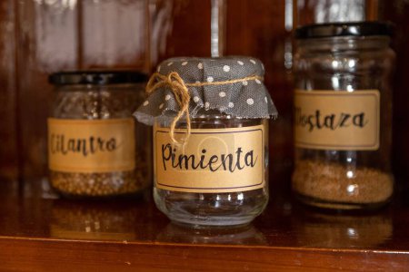 Photo for A closeup shot of jars with spices, with dotted cloths on lids, with names of spices written on each one - Royalty Free Image