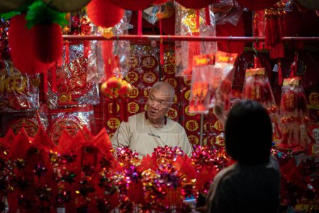 Téléchargez les photos : Homme au magasin vendant des décorations pour le Nouvel An chinois du lapin 2023 à Chinatown. - en image libre de droit