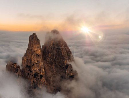 Téléchargez les photos : Vue aérienne du sommet des Dolomites s'élevant dans une surface nuageuse au coucher du soleil - en image libre de droit