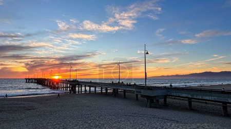 Téléchargez les photos : Coucher de soleil coloré illumine la plage, la jetée et l'océan à Los Angeles - en image libre de droit