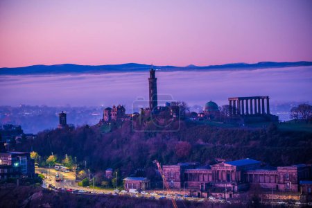 Téléchargez les photos : Une vue panoramique du siège d'Arthur sur Calton Hill couvert de nuages au coucher du soleil rose en Écosse - en image libre de droit